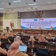 Peserta Dharma Wanita Persatuan Kabupaten Probolinggo mengikuti kegiatan diseminasi dan pemantapan e-reporting di auditorium dengan layar besar menampilkan judul acara dan beberapa narasumber di atas panggung.