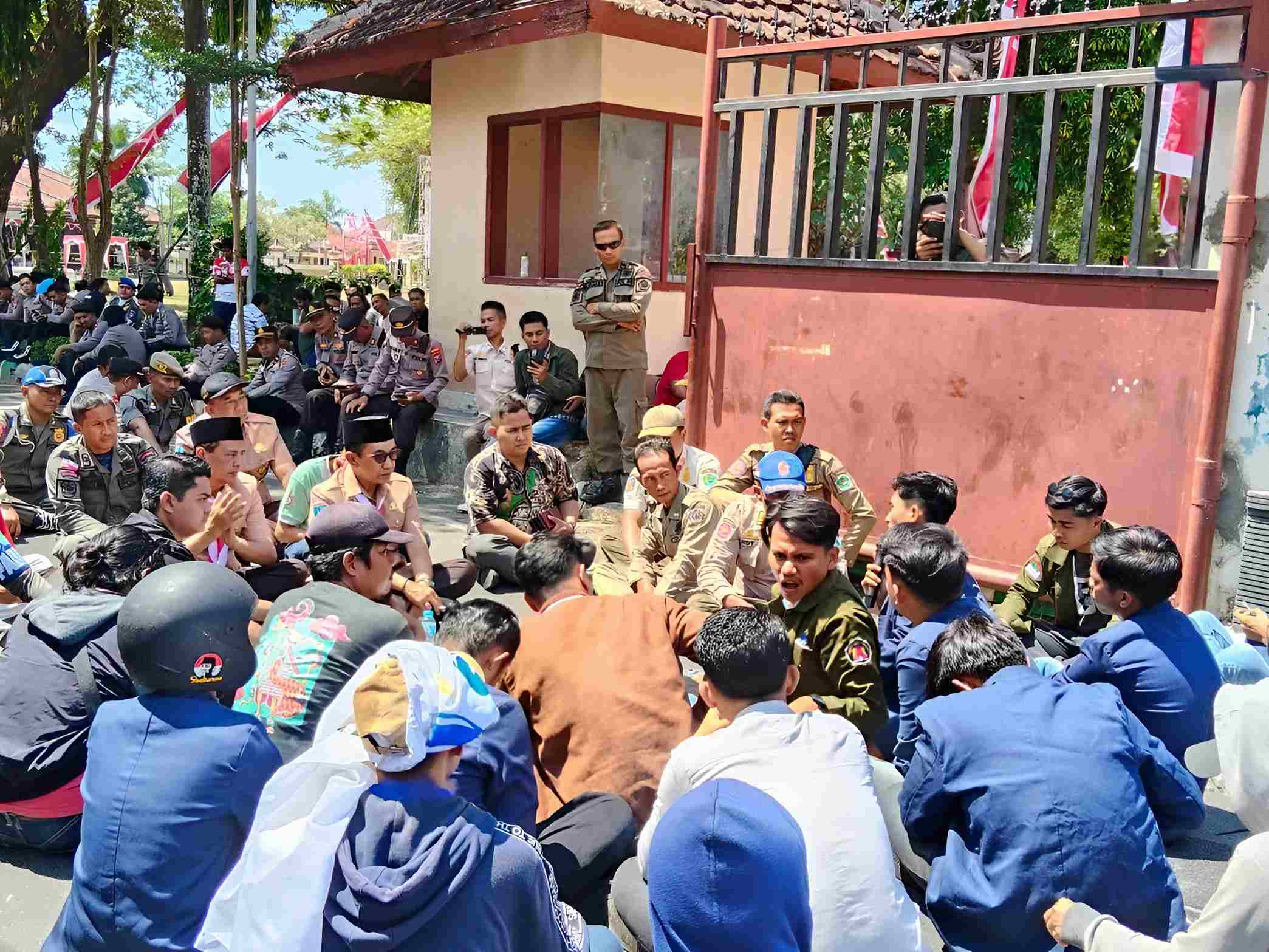 Bupati Pamekasan duduk bersama mahasiswa UNIRA di tengah aksi unjuk rasa di halaman kantor bupati.