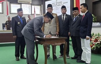 Bupati Pamekasan menandatangani dokumen penetapan dua perda baru disaksikan pimpinan DPRD di ruang rapat paripurna.