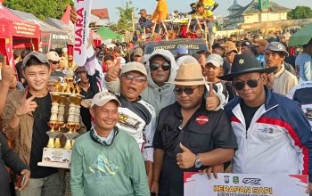 Kerumunan orang berpose dengan piala di acara Kerapan Sapi Kapolres Sumenep Cup 2025.