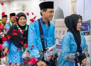 Sejumlah jemaah haji Indonesia mengenakan seragam biru dan peci hitam tiba di Madinah dengan wajah bahagia saat operasional haji 2026 berlangsung.