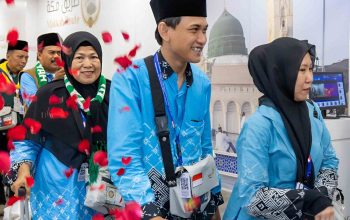 Sejumlah jemaah haji Indonesia mengenakan seragam biru dan peci hitam tiba di Madinah dengan wajah bahagia saat operasional haji 2026 berlangsung.