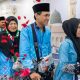 Sejumlah jemaah haji Indonesia mengenakan seragam biru dan peci hitam tiba di Madinah dengan wajah bahagia saat operasional haji 2026 berlangsung.