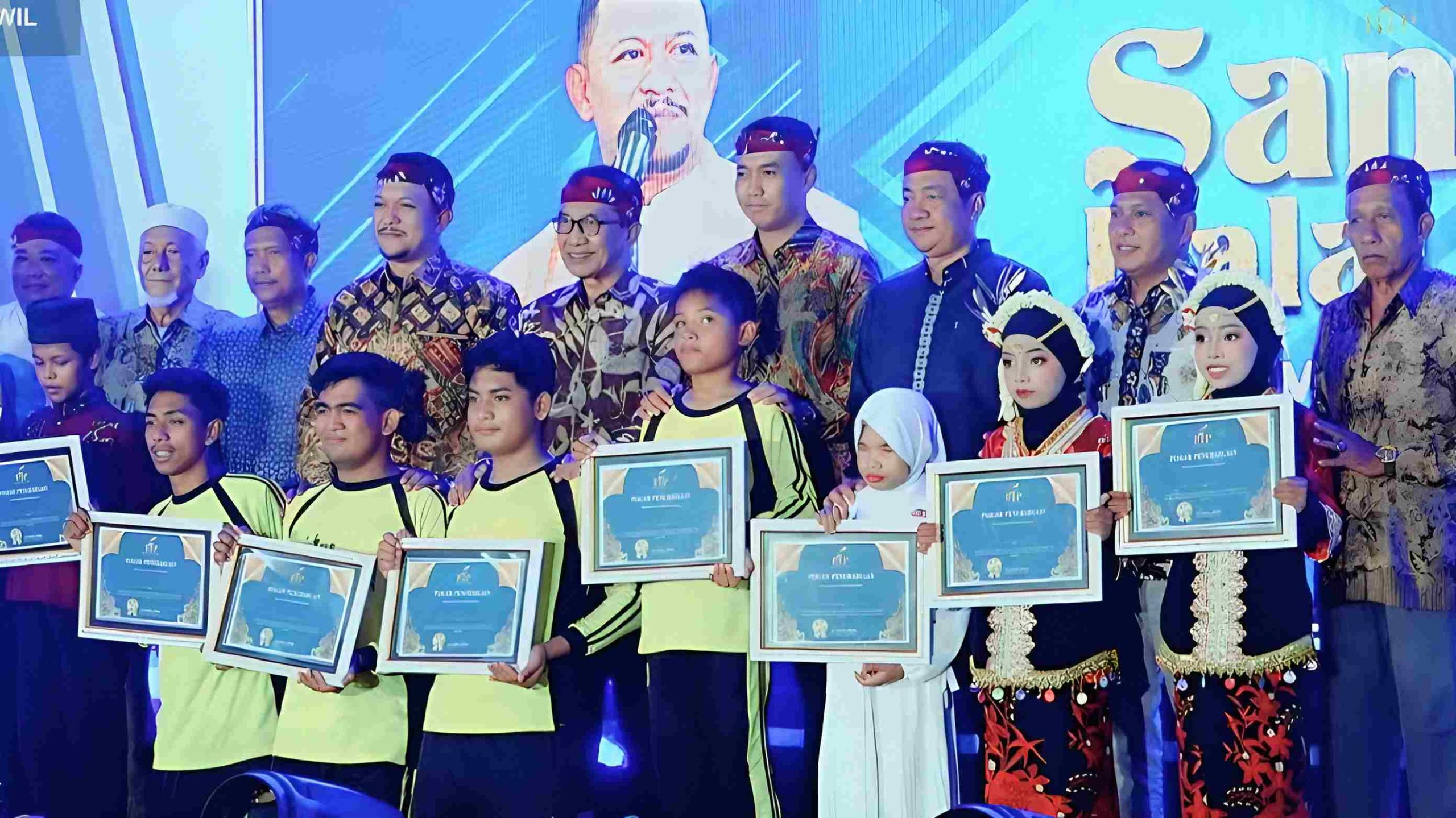 Bupati Pamekasan H Kholilurrahman bersama sejumlah pejabat dan peserta disabilitas berfoto sambil memegang piagam penghargaan pada acara santunan dan halal bihalal di Gedung Bakorwil Pamekasan.