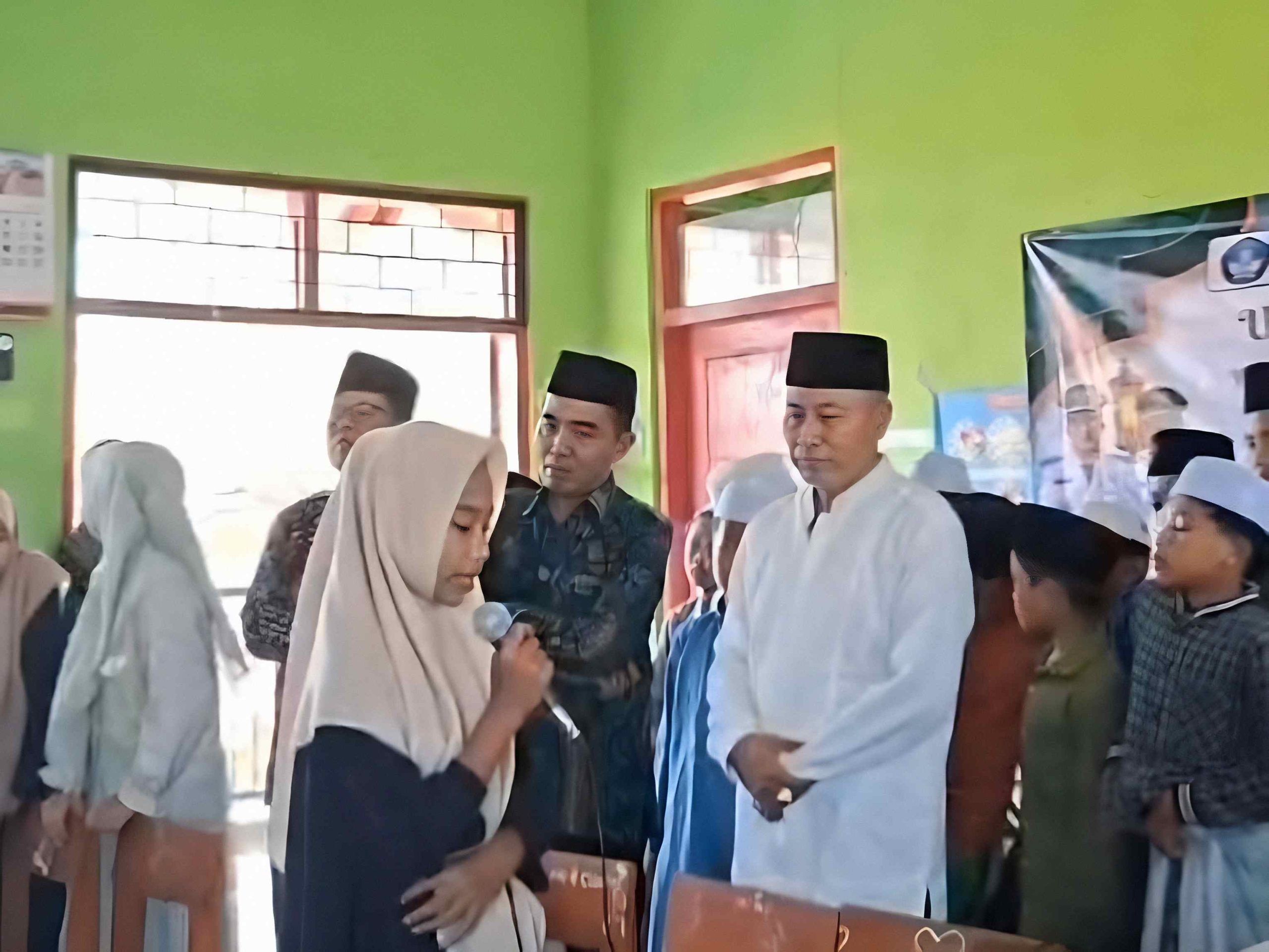 Siswi SD membaca Al-Qur’an menggunakan mikrofon saat Uji Kompetensi Al-Qur’an disaksikan guru dan pejabat di ruang kelas.