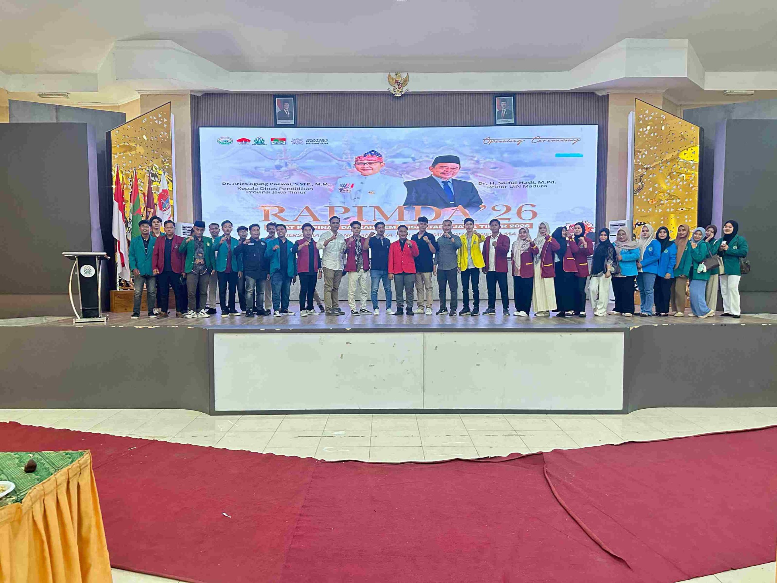 Foto bersama peserta RAPIMDA BEM Nusantara Jatim di auditorium pusat UIN Madura dengan latar belakang banner kegiatan dan pejabat undangan.