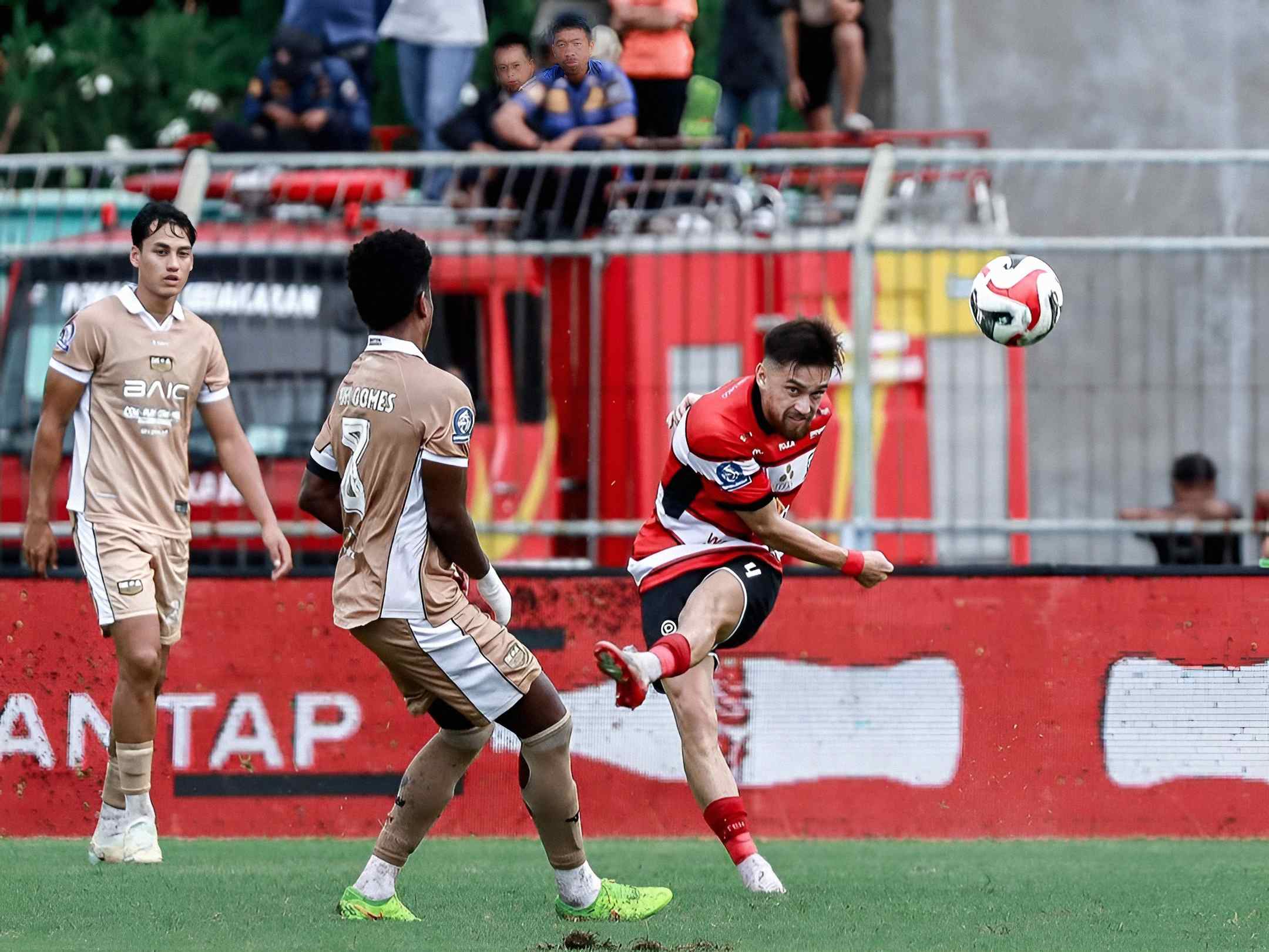 Pemain Madura United menendang bola saat mendapat tekanan pemain Dewa United dalam pertandingan Super League 2025/2026 di Stadion Gelora Bangkalan.