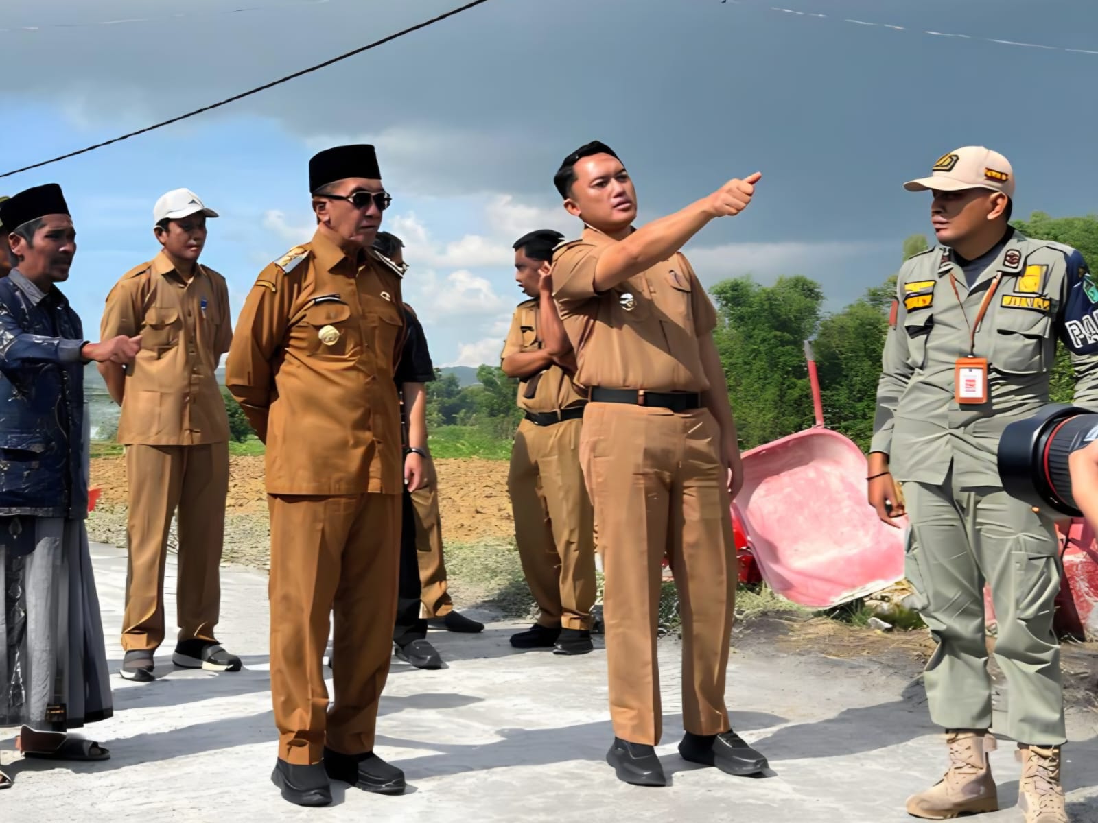 Bupati Pamekasan Kholilurrahman bersama pejabat daerah meninjau pembangunan jalan desa sambil berdiskusi di lokasi proyek.
