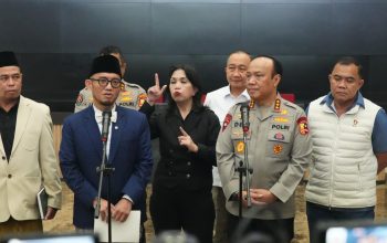 Pejabat pemerintah dan kepolisian Indonesia memberikan pernyataan pers terkait penanganan haji ilegal dengan penerjemah bahasa isyarat di tengah.