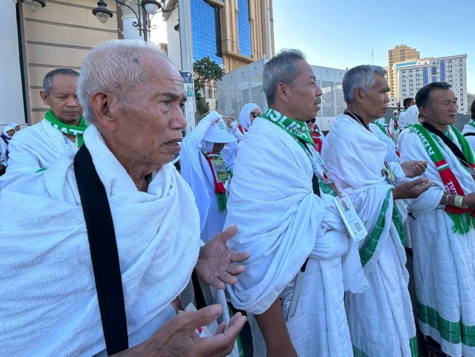 Jemaah haji Indonesia mengenakan kain ihram berdoa bersama di area sekitar Masjidil Haram, Makkah.
