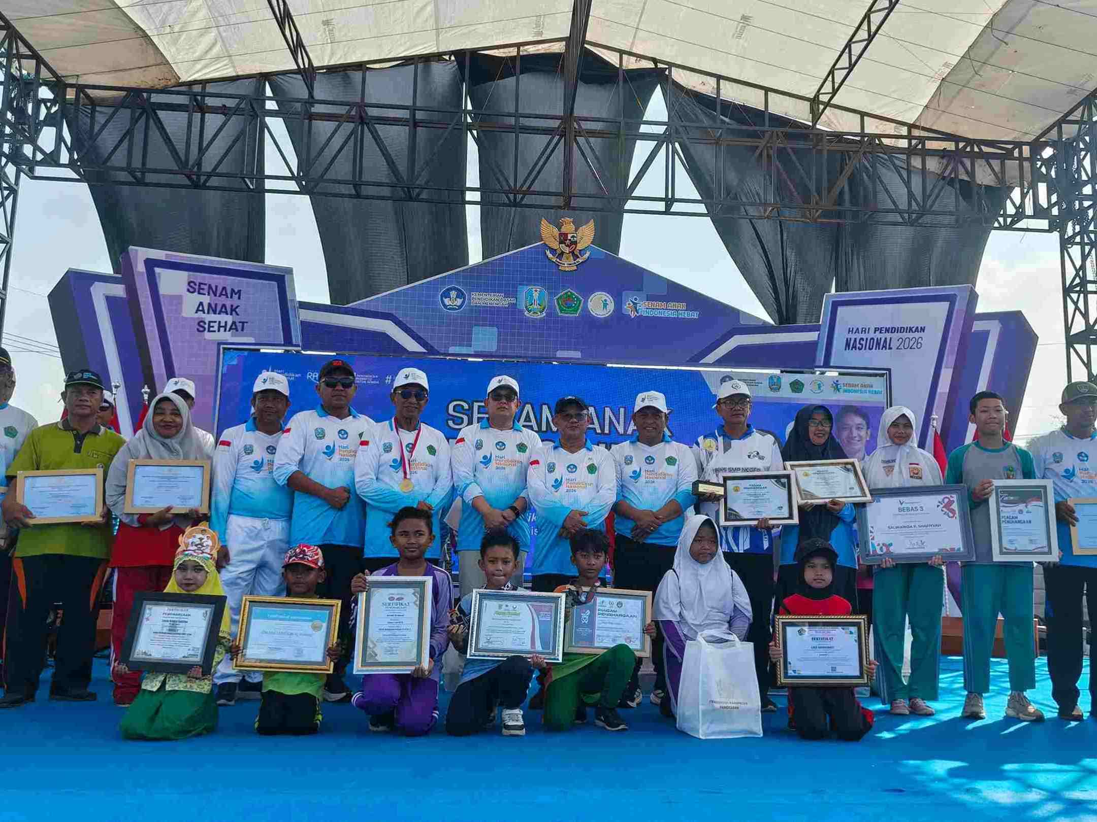 Bupati Pamekasan dan Mendikdasmen Abdul Mu’ti berfoto bersama siswa dan tenaga pendidik penerima penghargaan pada Hardiknas 2026 di Pamekasan.