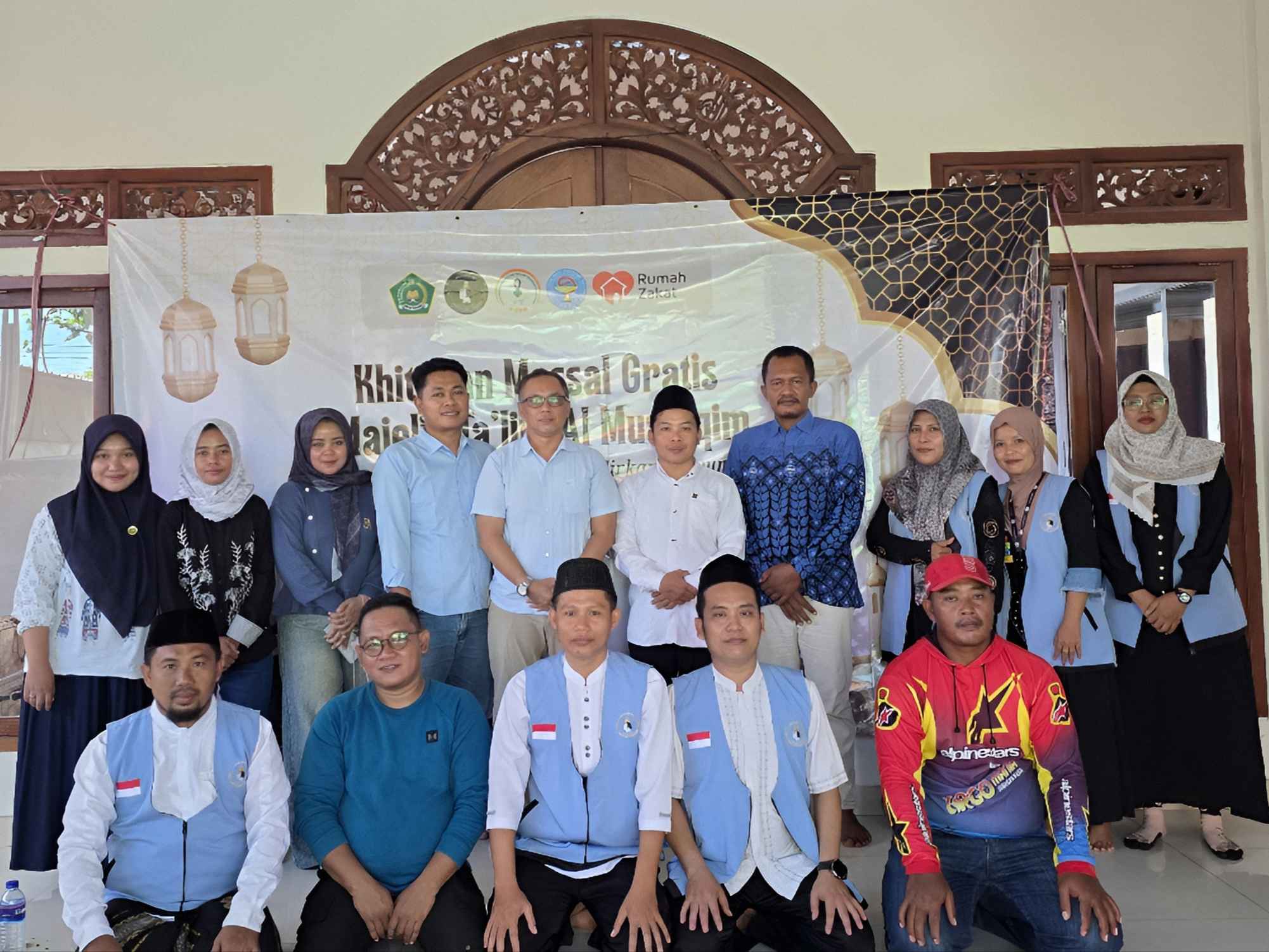Sekelompok panitia Yayasan PSBB, PAFI Pamekasan dan Majelis Ta'lim Al Mustaqim berfoto bersama spanduk Khitan Massal Gratis.