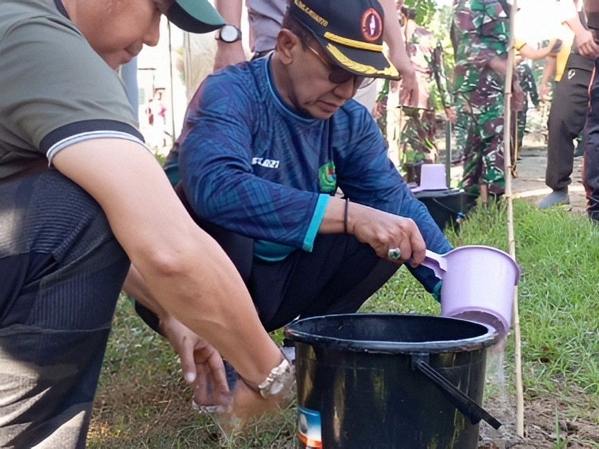 Bupati Pamekasan Dr. KH. Kholilurrahman menyiram bibit pohon dalam kegiatan Gerakan Indonesia Serentak di Taman Asri Kowel, Kelurahan Kowel, Jumat (10/7/2026).