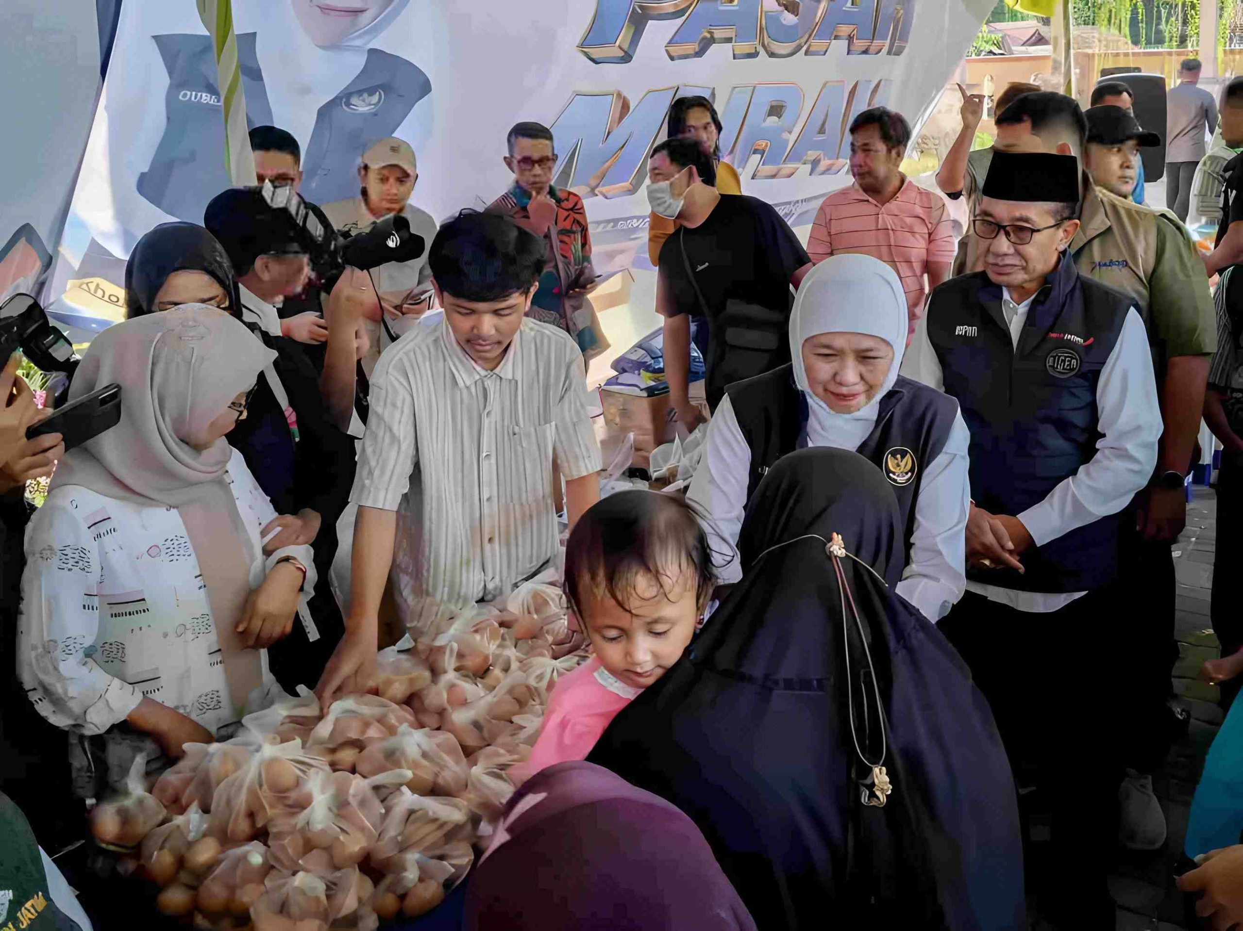Gubernur Jawa Timur didampingi Bupati Pamekasan berinteraksi dengan masyarakat saat meninjau pasar murah di Kecamatan Larangan, Kabupaten Pamekasan. Deskripsi: