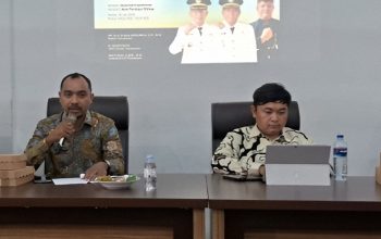 Kabid IKP Diskominfo Kabupaten Pamekasan, Arif Rachmansyah, memberikan materi pelatihan pembuatan konten publik kepada peserta OPD didampingi seorang narasumber di ruang pelatihan.