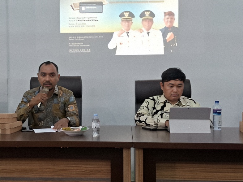Kabid IKP Diskominfo Kabupaten Pamekasan, Arif Rachmansyah, memberikan materi pelatihan pembuatan konten publik kepada peserta OPD didampingi seorang narasumber di ruang pelatihan.