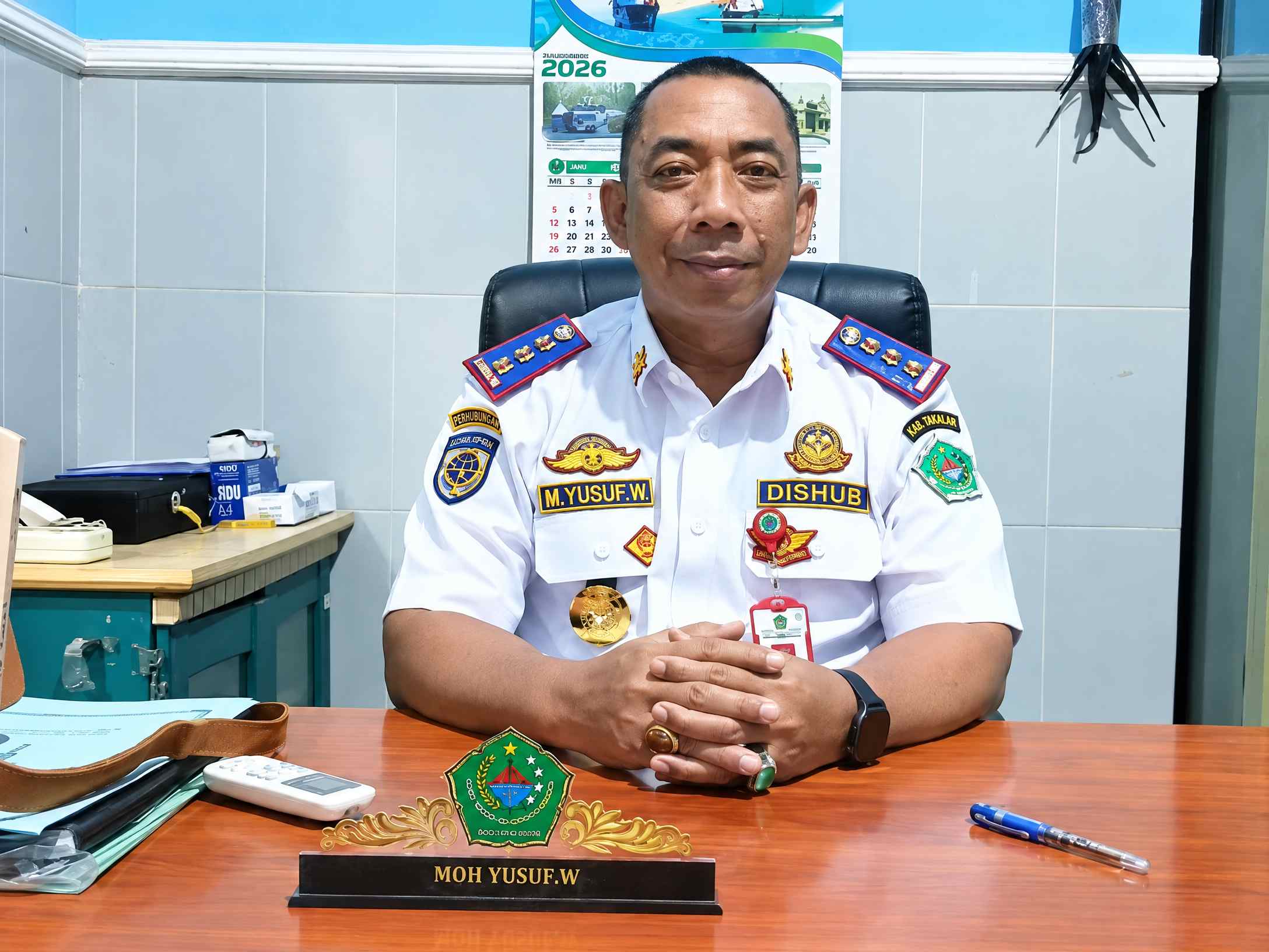 Kepala Dishub Pamekasan M Yusuf Wibiseno duduk di ruang kerja saat menjelaskan capaian retribusi parkir.