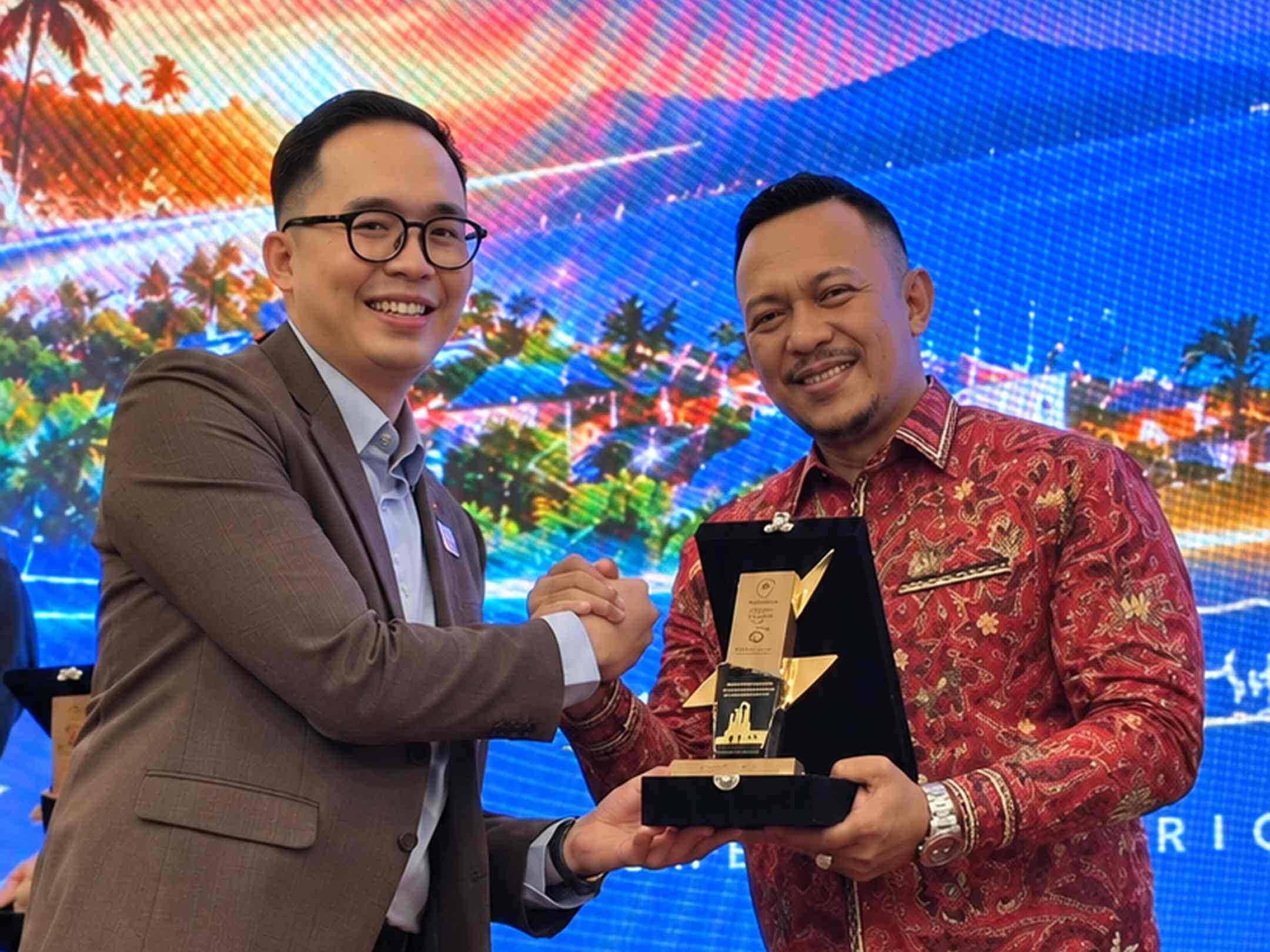 Manager PLN UP3 Madura Radea Cakrawala N bersama CEO PT BANI Group H. Ali Zainal Abidin memegang penghargaan pada acara Priority Customer Gathering 2026.