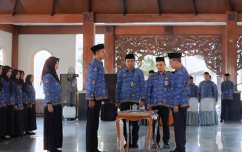 Bupati Pamekasan berdiri bersama sejumlah aparatur berseragam biru dalam prosesi pengambilan sumpah PNS.