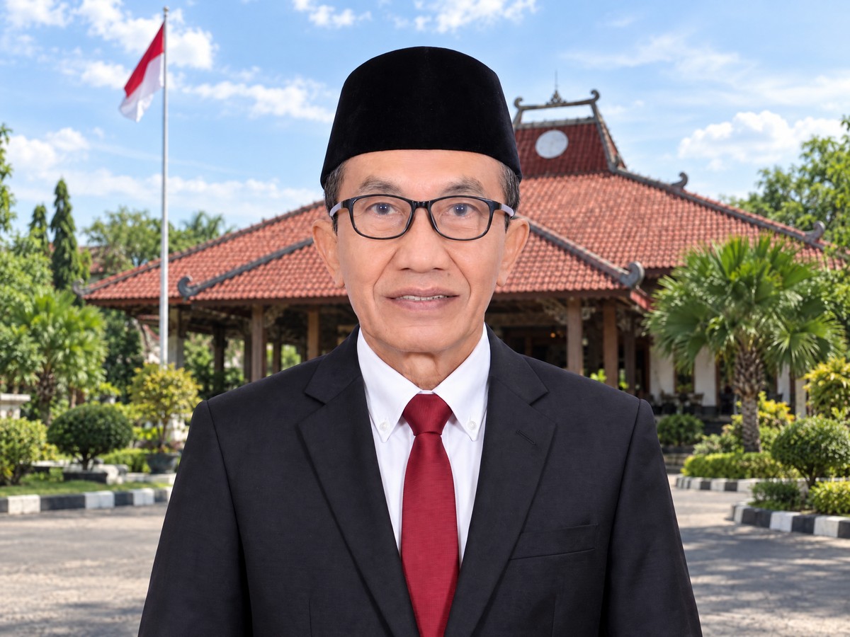 Bupati Pamekasan Kholilurrahman mengenakan jas dan peci dengan latar Pendopo Ronggosukowati.