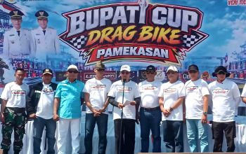 Panitia dan peserta Bupati Cup Drag Bike Pamekasan berfoto di depan panggung acara.
