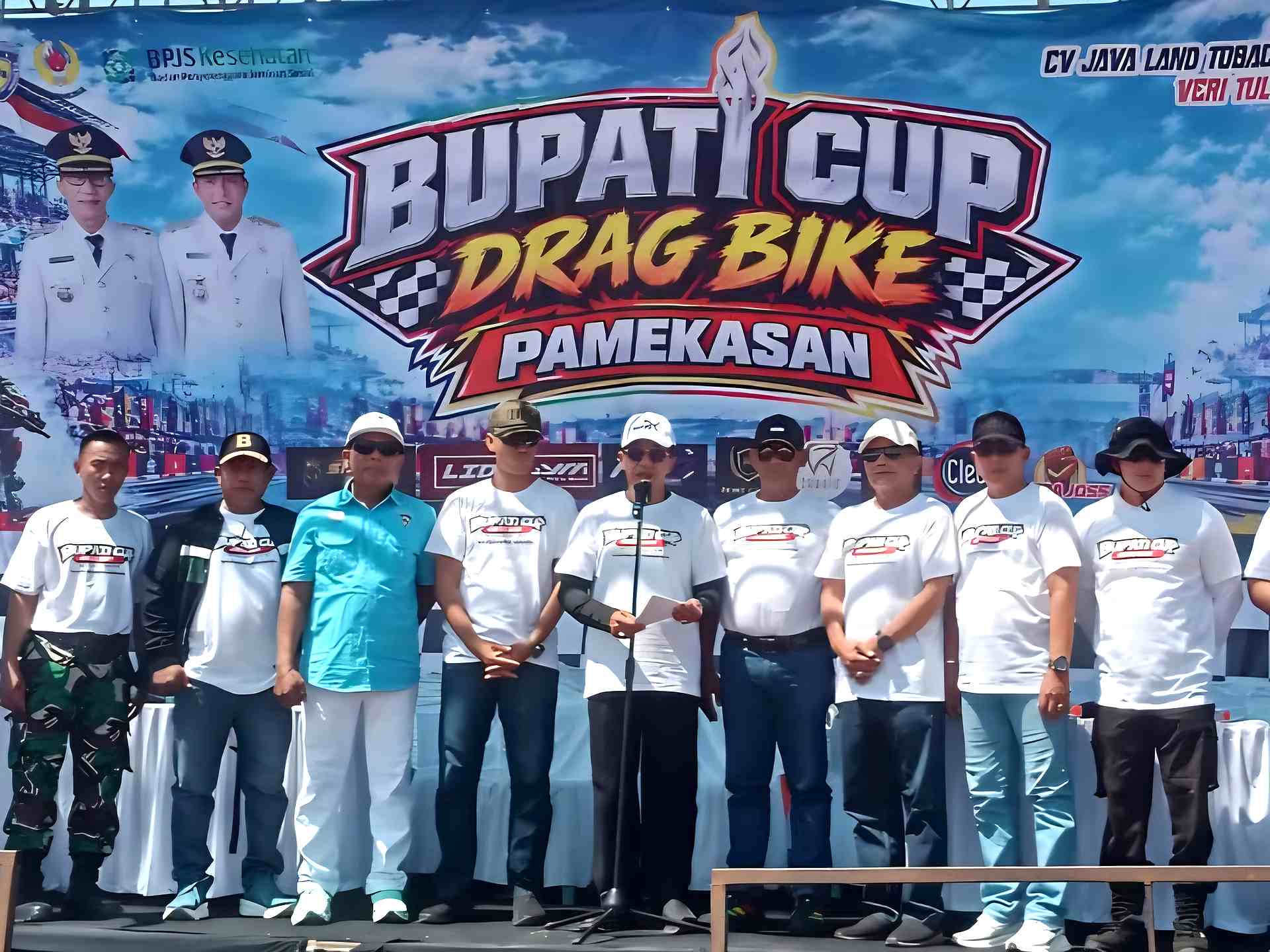 Panitia dan peserta Bupati Cup Drag Bike Pamekasan berfoto di depan panggung acara.